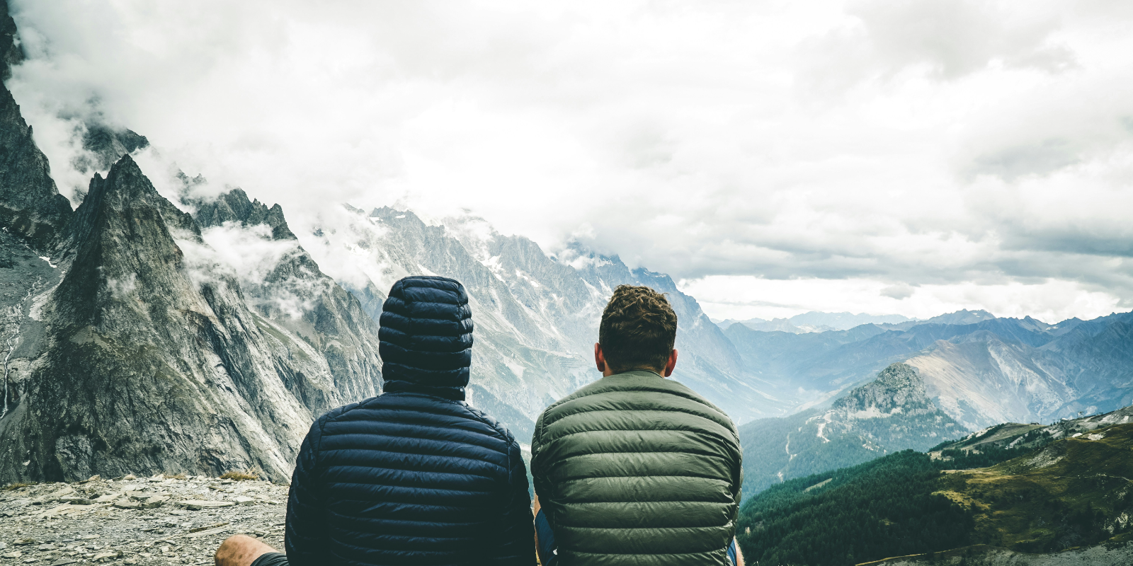 Two people standing together above a sea of cloud
