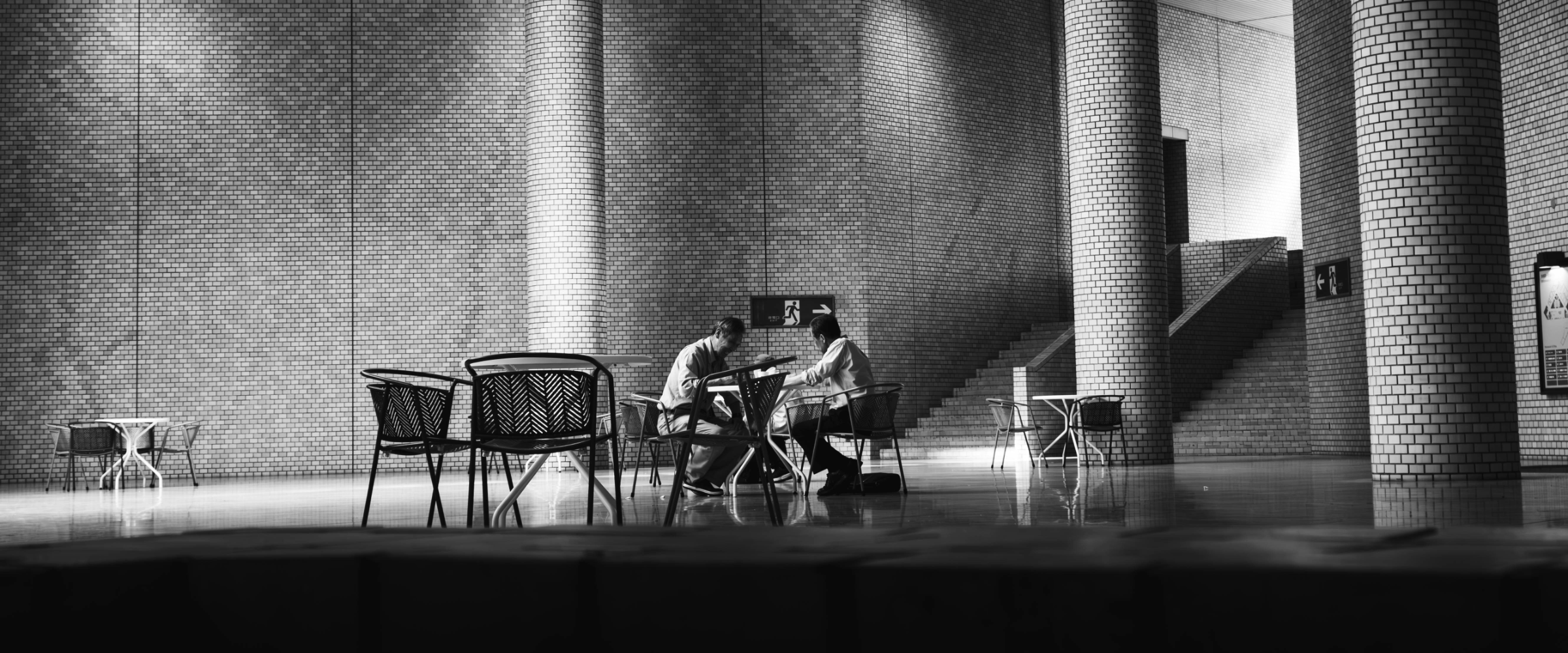 Two people in quiet conversation in a large lobby