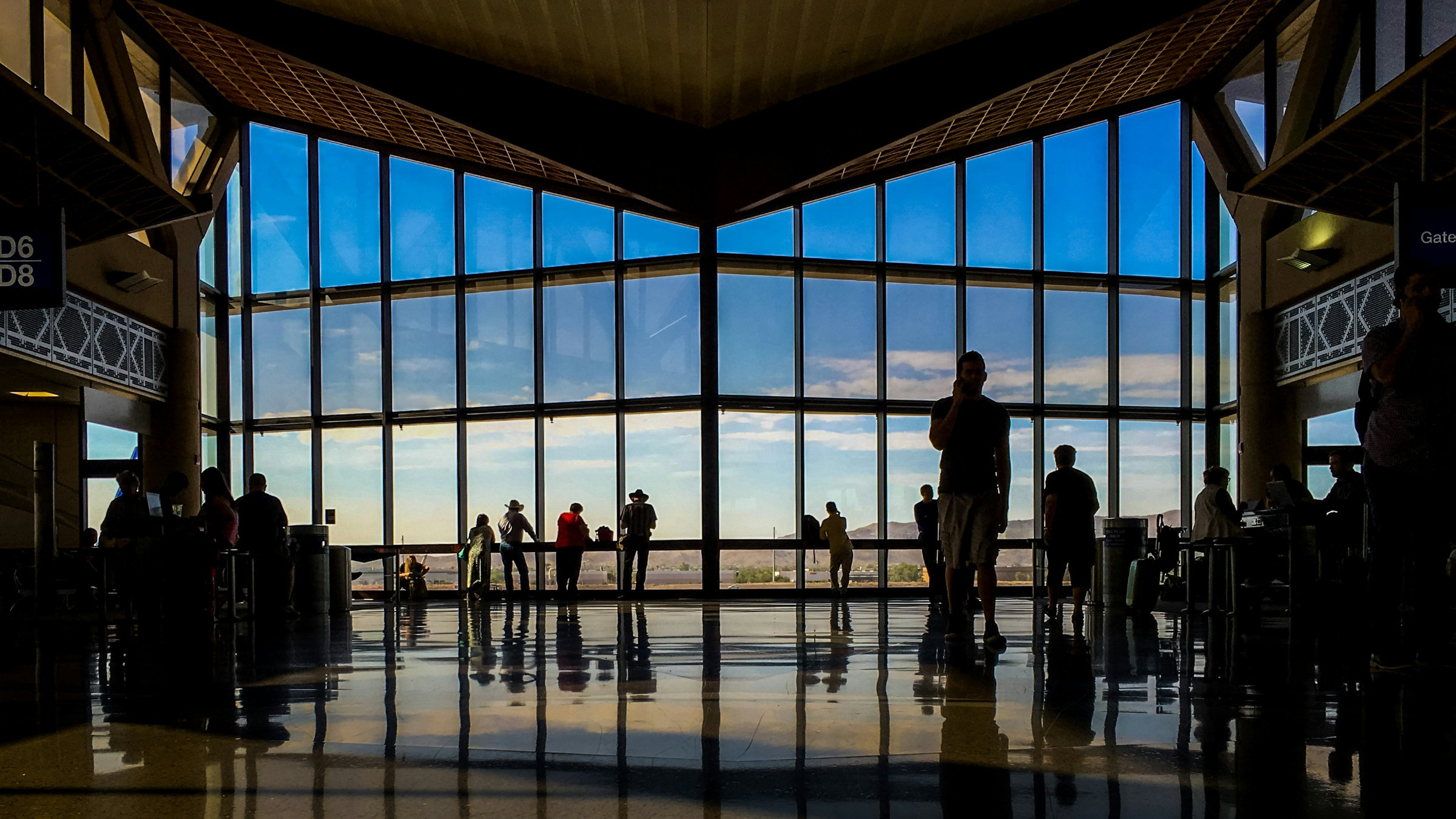 Travellers silhouetted against a terminal window